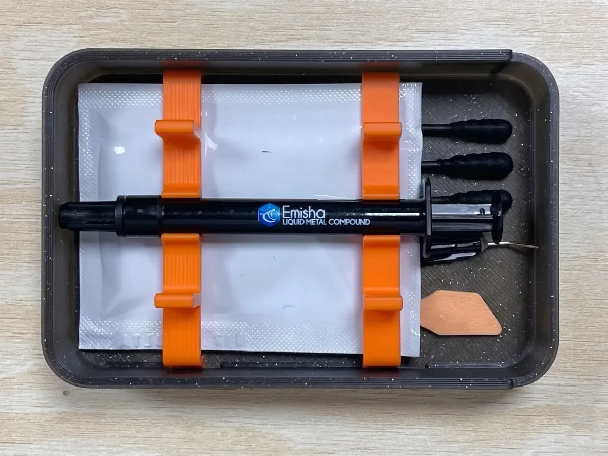 Vista superior del estuche Emisha Liquid Ultra con la jeringa, la aguja aplicadora y la espátula